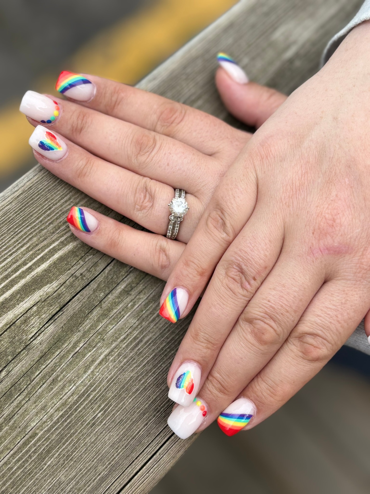 White nails with rainbow tips and heart pride art by TwentyOne Nails and Spa