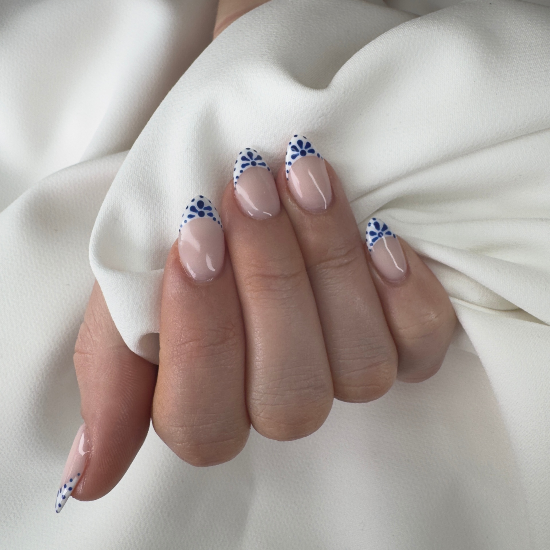 Nude almond nails with blue Portuguese tile flower French tips